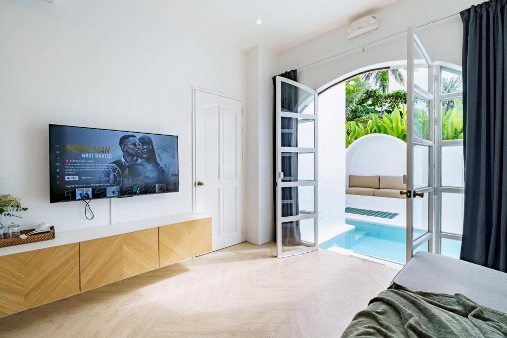 Suite living area with Smart TV and arched doors to pool