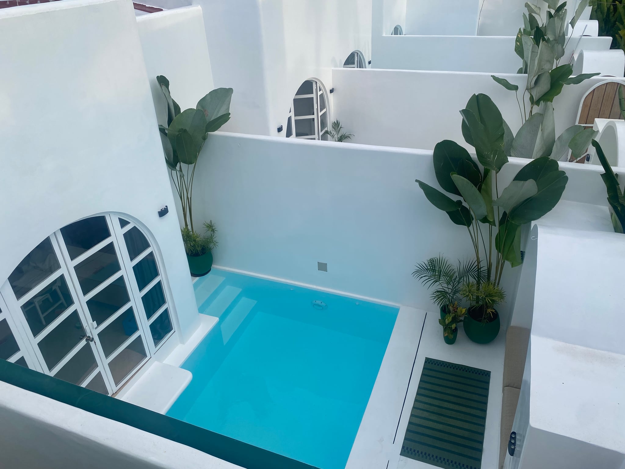 Aerial view of Amanzohi Siargao - white Mediterranean architecture with turquoise pools and tropical plants